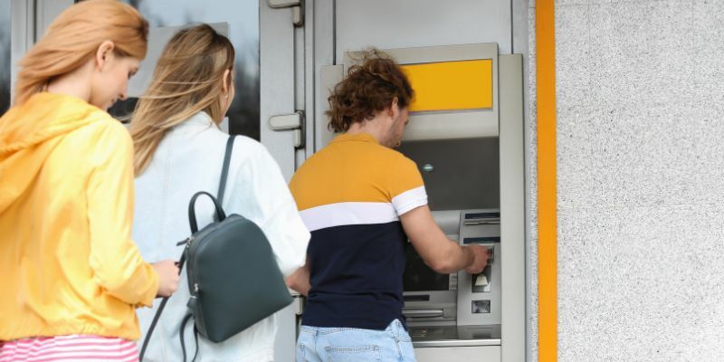 the people stnding in line waiting for their turn to use ATM machine