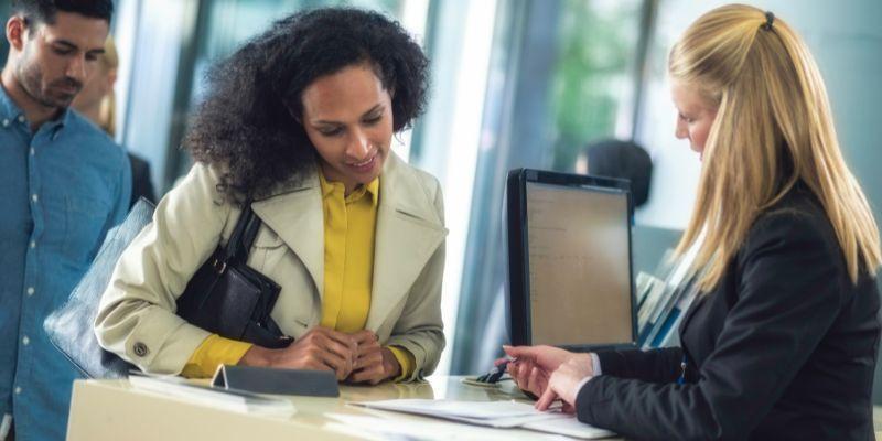 Bank-teller-explaining-process-to-customer-in-line